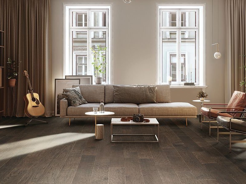 Hardwood floors in a living room with large windows.